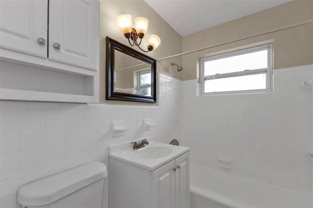 full bathroom featuring vanity, tile walls, tiled shower / bath combo, and toilet