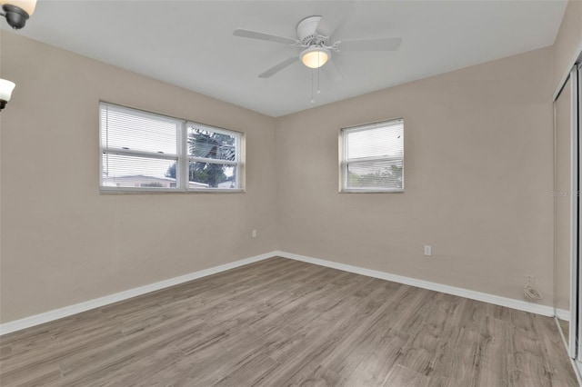 spare room with ceiling fan, light hardwood / wood-style floors, and a healthy amount of sunlight