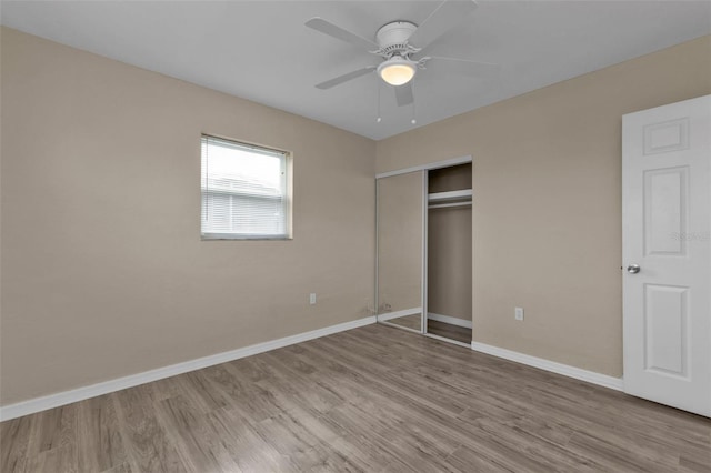 unfurnished bedroom with light wood-type flooring, ceiling fan, and a closet