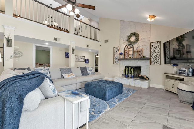 living room featuring a large fireplace, high vaulted ceiling, and ceiling fan