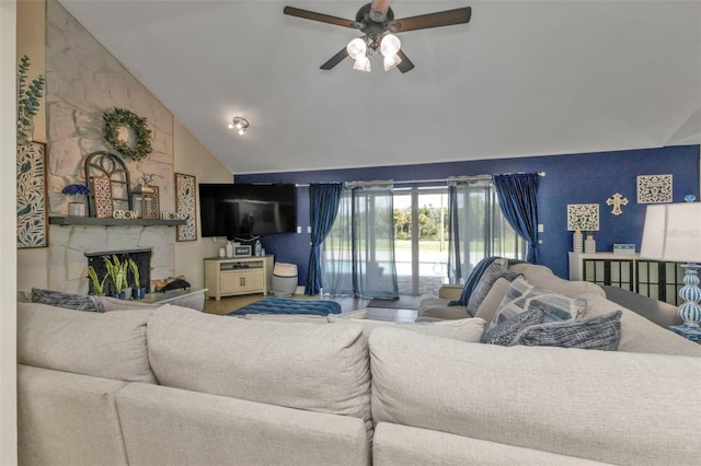 living room with high vaulted ceiling, ceiling fan, and a stone fireplace