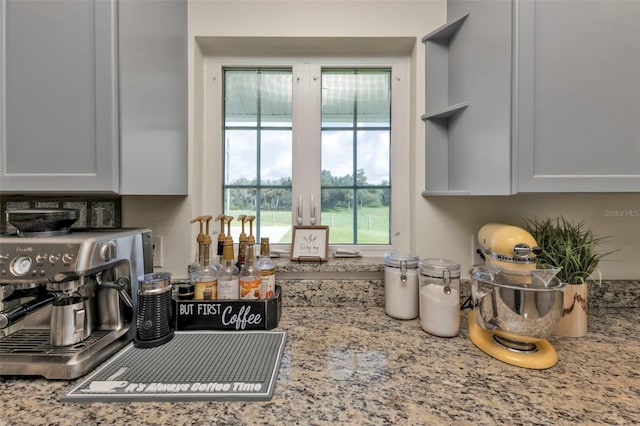 kitchen featuring light stone countertops and white cabinetry