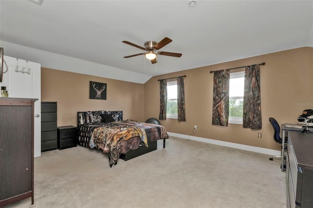 carpeted bedroom featuring multiple windows, ceiling fan, and lofted ceiling