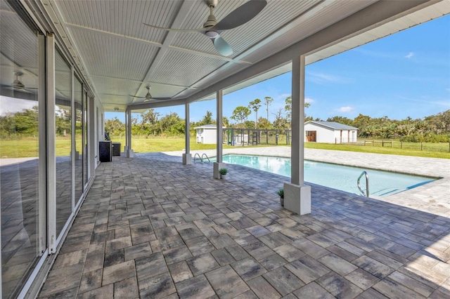 view of pool with a yard, a patio, and ceiling fan