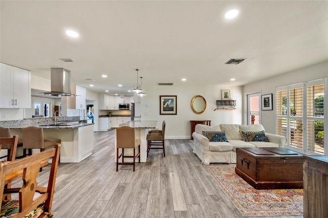 living room with sink and light wood-type flooring