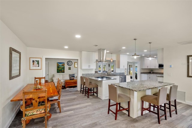 kitchen featuring a breakfast bar, white cabinets, and light hardwood / wood-style floors