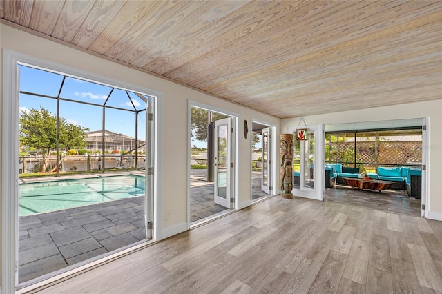 unfurnished sunroom with wood ceiling and a swimming pool