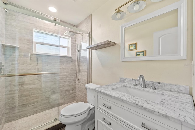 bathroom featuring walk in shower, toilet, and vanity