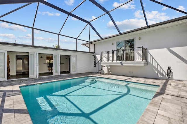 view of pool featuring glass enclosure and a patio area