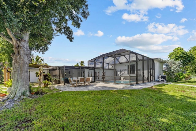 back of house with glass enclosure, a lawn, and a patio area