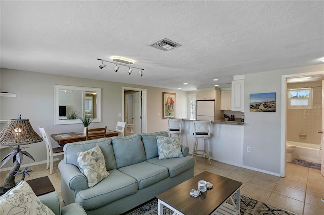 living room featuring a textured ceiling and light tile patterned flooring