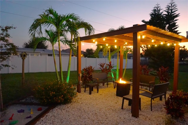 patio terrace at dusk featuring a lawn