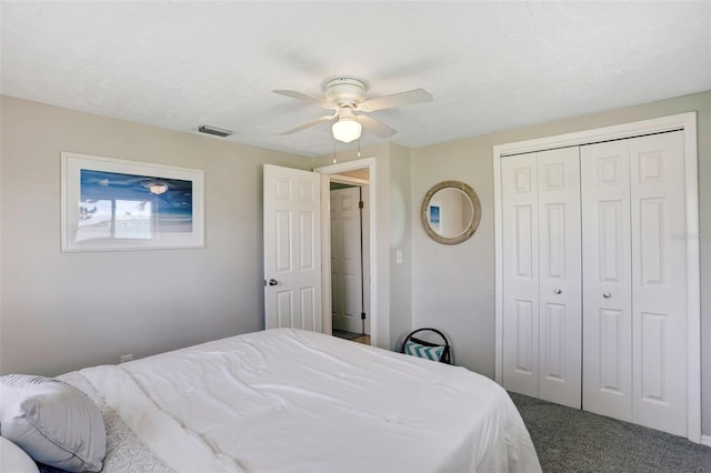 carpeted bedroom featuring ceiling fan, a textured ceiling, and a closet