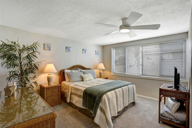 bedroom featuring ceiling fan, light colored carpet, and a textured ceiling