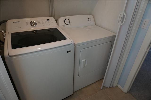 washroom featuring washer and clothes dryer and light tile patterned floors