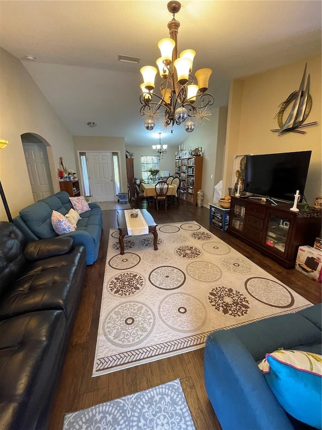 living room with dark wood-type flooring, vaulted ceiling, and a notable chandelier