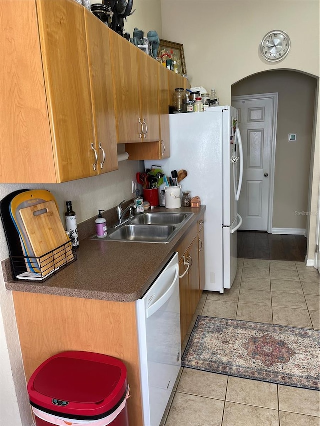 kitchen with light tile patterned floors, sink, and white dishwasher