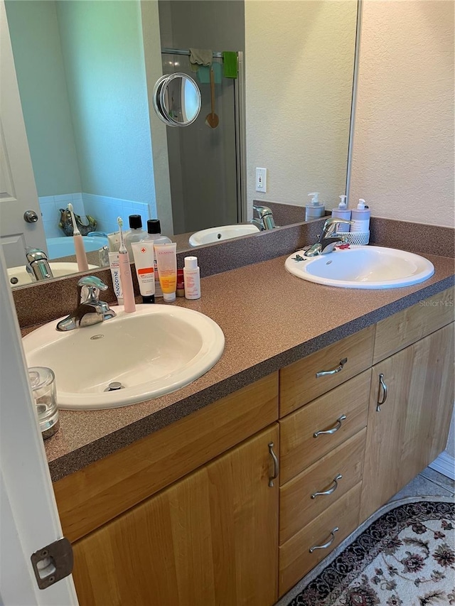 bathroom with vanity, a shower with shower door, and tile patterned flooring