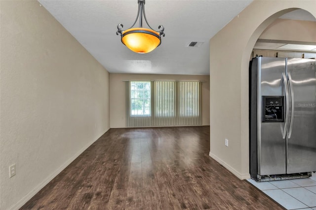 interior space with stainless steel refrigerator with ice dispenser and hardwood / wood-style flooring