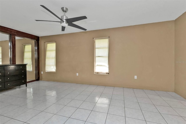 tiled spare room with ceiling fan