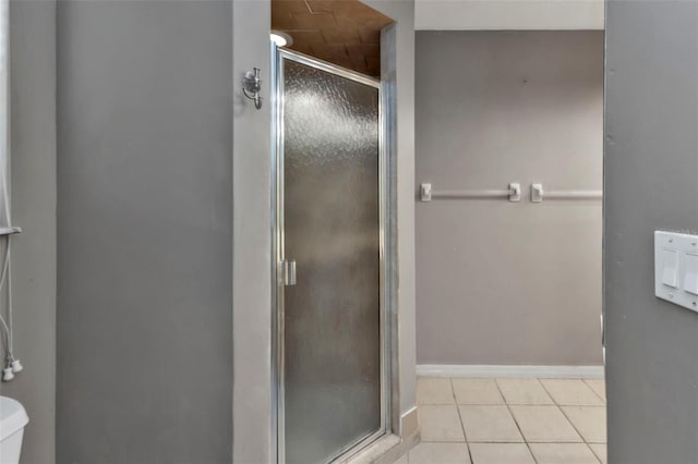 bathroom with walk in shower, toilet, and tile patterned floors