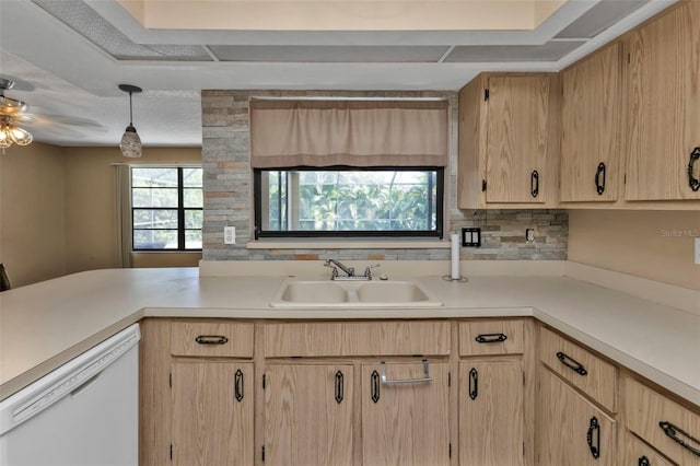 kitchen with backsplash, white dishwasher, light brown cabinetry, decorative light fixtures, and sink