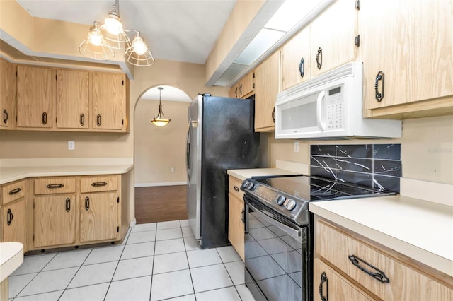 kitchen featuring hanging light fixtures, decorative backsplash, light tile patterned flooring, stainless steel refrigerator, and black electric range