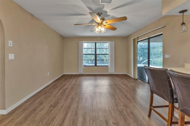 unfurnished dining area with ceiling fan and hardwood / wood-style flooring