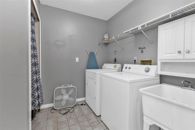 clothes washing area with light tile patterned floors, cabinets, sink, and washing machine and dryer