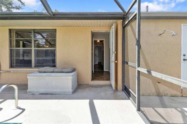 view of exterior entry with a patio area