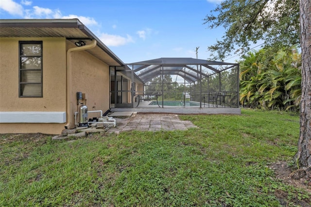 view of yard with glass enclosure and a patio area