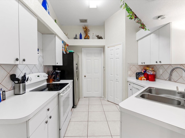 kitchen featuring white appliances, white cabinetry, and decorative backsplash