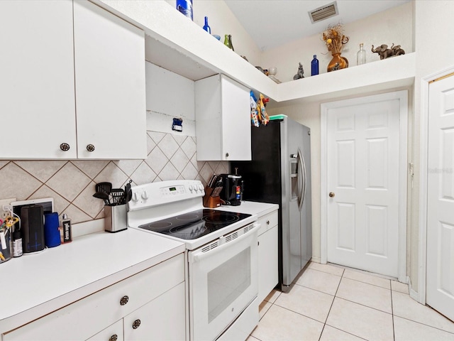 kitchen with white cabinets, backsplash, light tile patterned floors, and electric stove