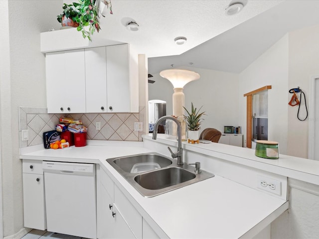 kitchen with dishwasher, kitchen peninsula, sink, and backsplash