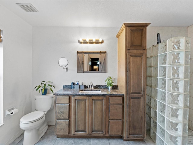 bathroom with vanity, toilet, tile patterned floors, and walk in shower