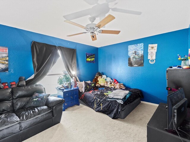 bedroom featuring ceiling fan and carpet