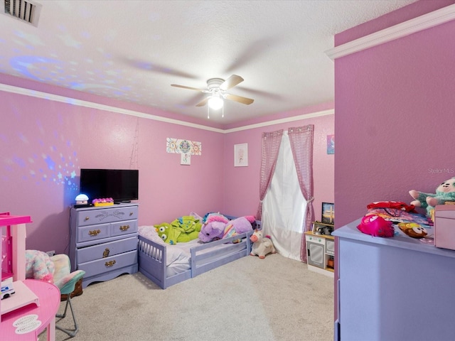 bedroom with light colored carpet, ceiling fan, and a textured ceiling