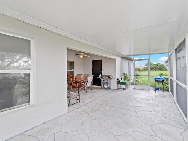 unfurnished sunroom with ceiling fan