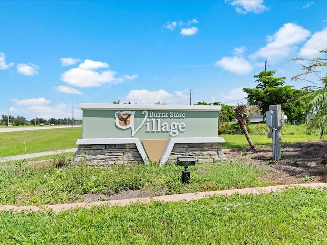 community / neighborhood sign with a yard