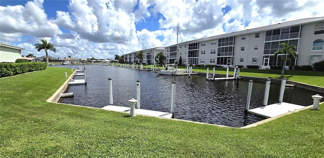 dock area with a lawn and a water view