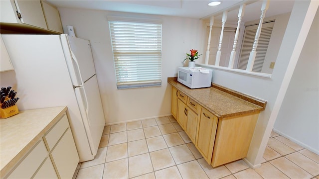 kitchen with white appliances and light tile patterned floors