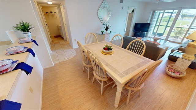 dining area with ceiling fan and light wood-type flooring