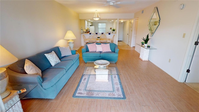 living room with light hardwood / wood-style flooring and ceiling fan