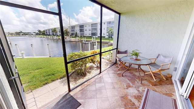 unfurnished sunroom featuring a water view