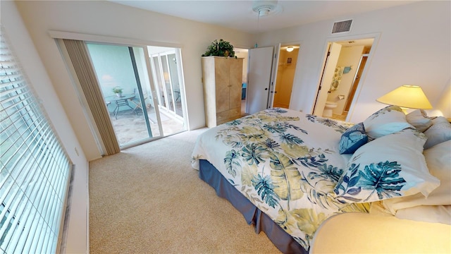 carpeted bedroom featuring multiple windows, ceiling fan, access to outside, and ensuite bath