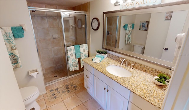 bathroom with vanity, toilet, tile patterned floors, and walk in shower