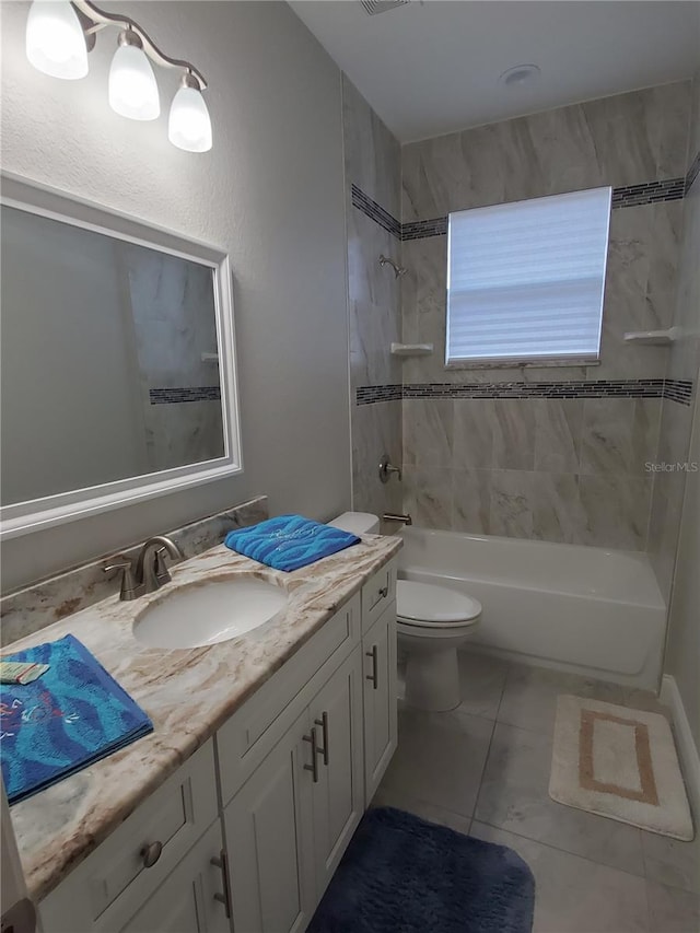 full bathroom featuring tiled shower / bath combo, vanity, toilet, and tile patterned floors