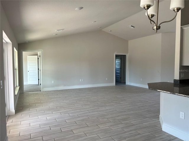 unfurnished living room with a chandelier, lofted ceiling, and light wood-type flooring