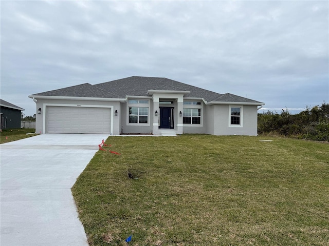 view of front of home featuring an attached garage, driveway, a front lawn, and stucco siding