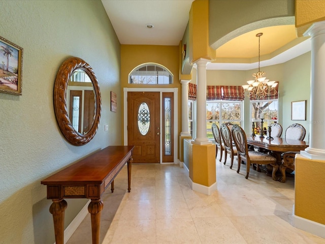 foyer featuring a chandelier and ornate columns